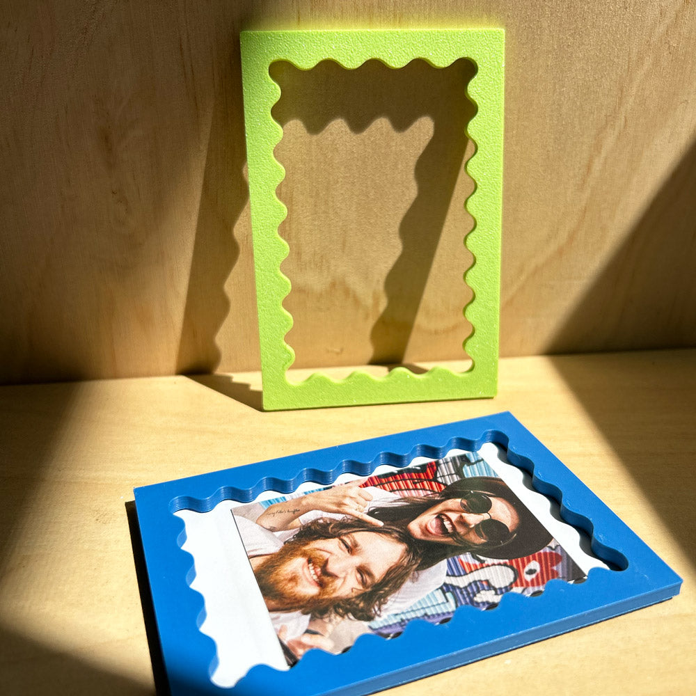 Green and blue photo frames on a wooden surface