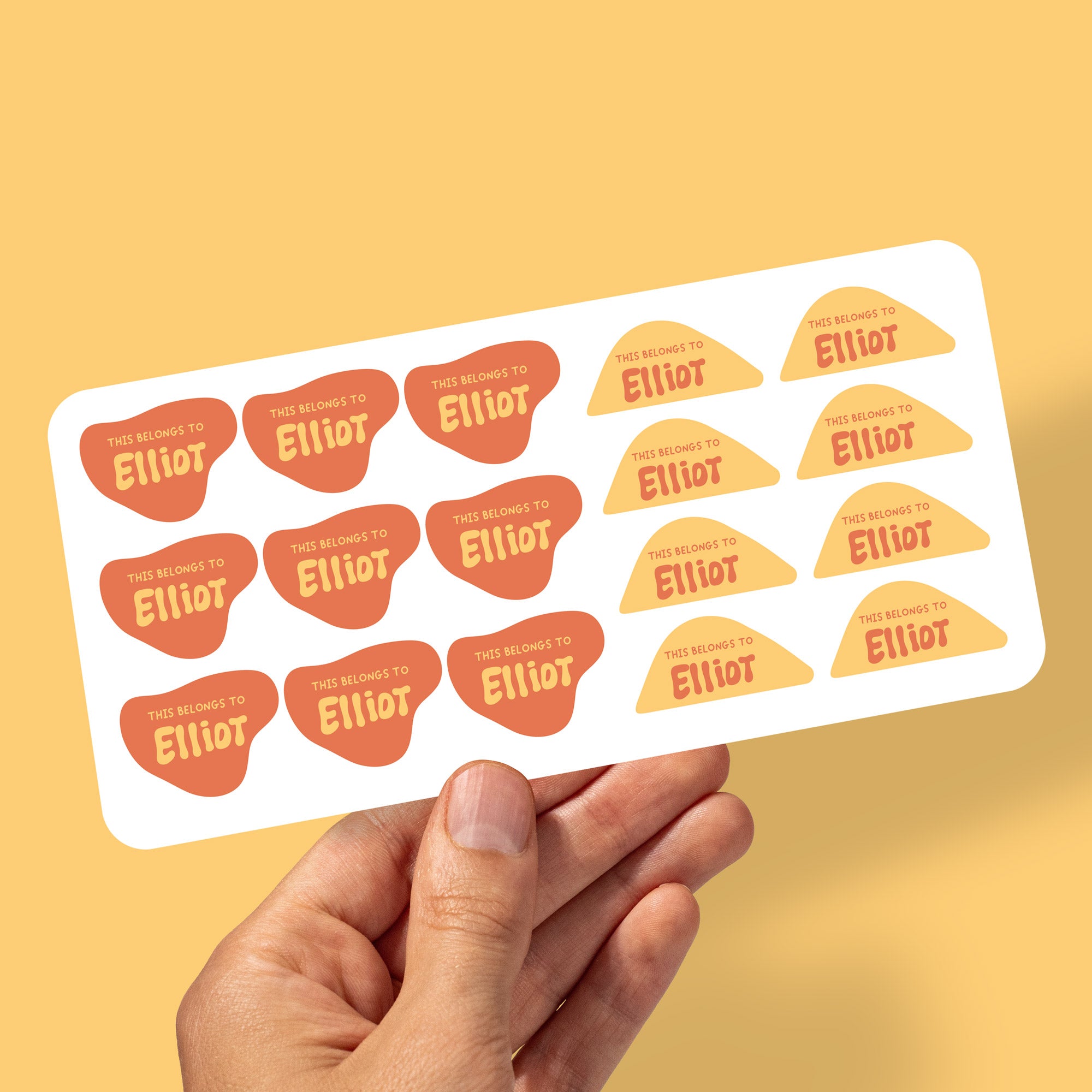 hand holding kids name stickers for daycare