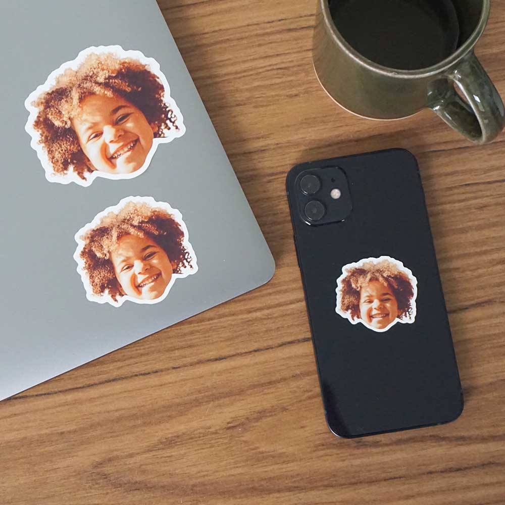 kid's face as a sticker stuck on a laptop and iphone