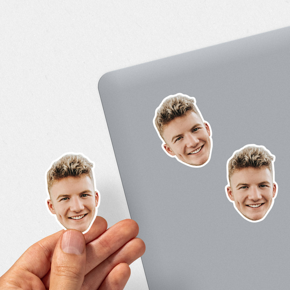 Three stickers of a smiling person on a laptop