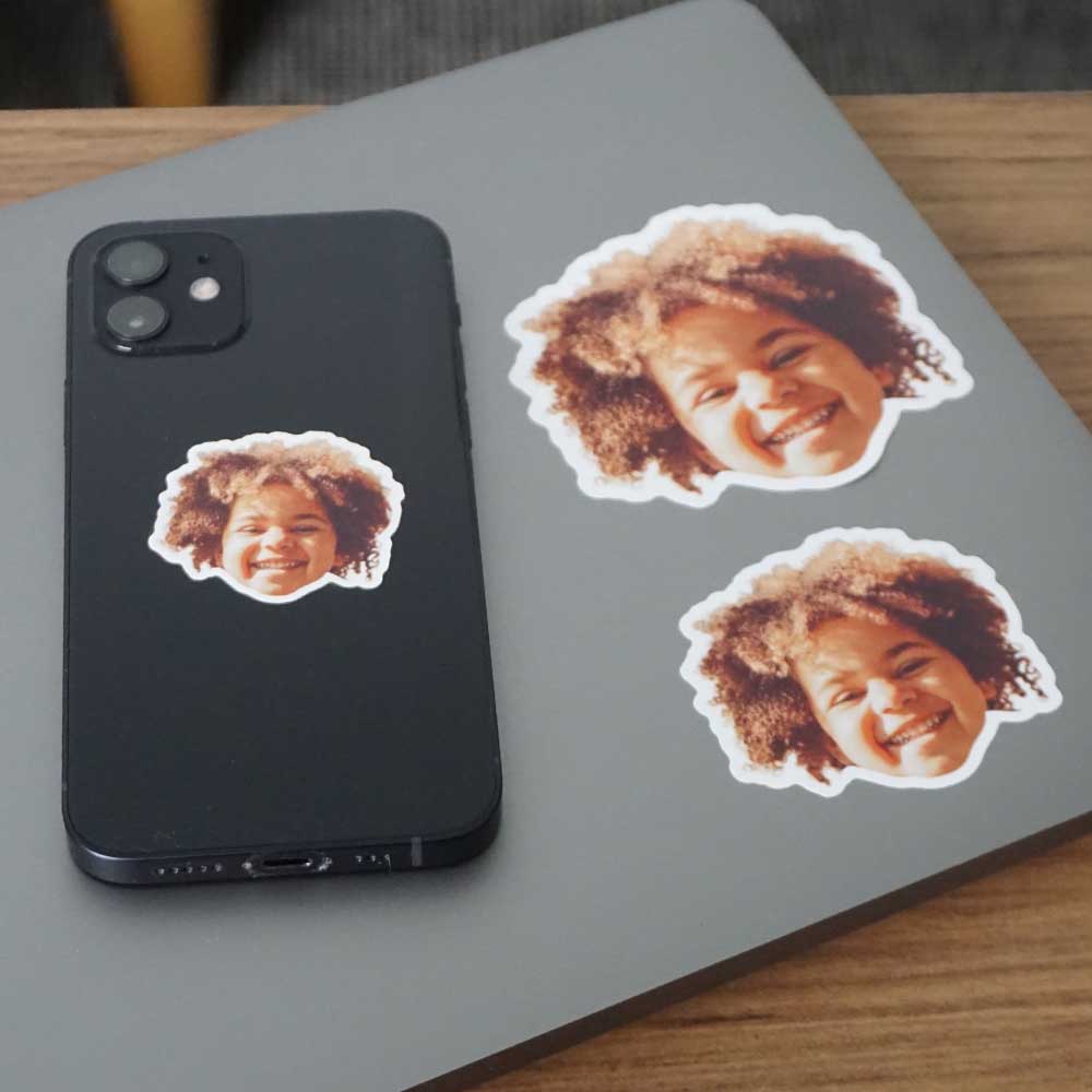 kid's face as a sticker stuck on a laptop and iphone